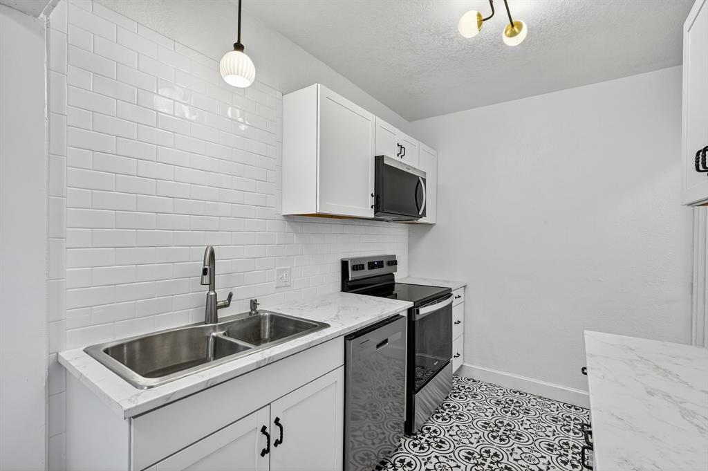 513 Northwest 6th Street, Unit 4 Mineral Wells, TX 76067 - Photo 7 of 34 a kitchen that has a sink and a stove top oven