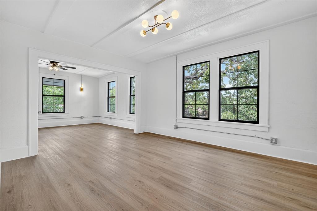 513 Northwest 6th Street, Unit 4 Mineral Wells, TX 76067 - Photo 9 of 34 a view of an empty room with wooden floor and a window