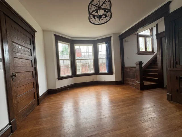 a view of an empty room with window and fire place