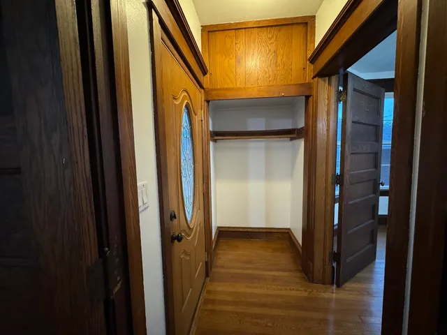 a view of a hallway with wooden floor and a living room