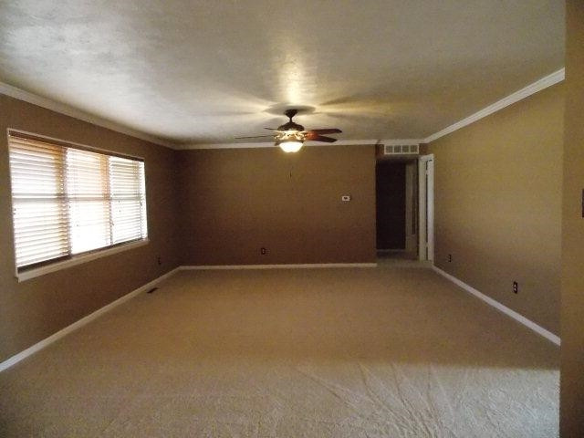 4702 31st Street Lubbock, TX 79410 - Photo 2 of 10 an empty room with a ceiling fan and window