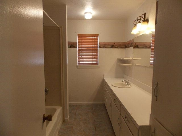 4702 31st Street Lubbock, TX 79410 - Photo 9 of 10 a bathroom with a sink a toilet and shower