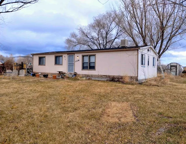 a front view of house with yard and trees around