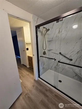 a bathroom with a glass door shower and a sink