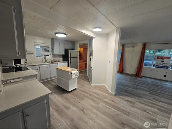 a kitchen with a sink appliances and wooden floor