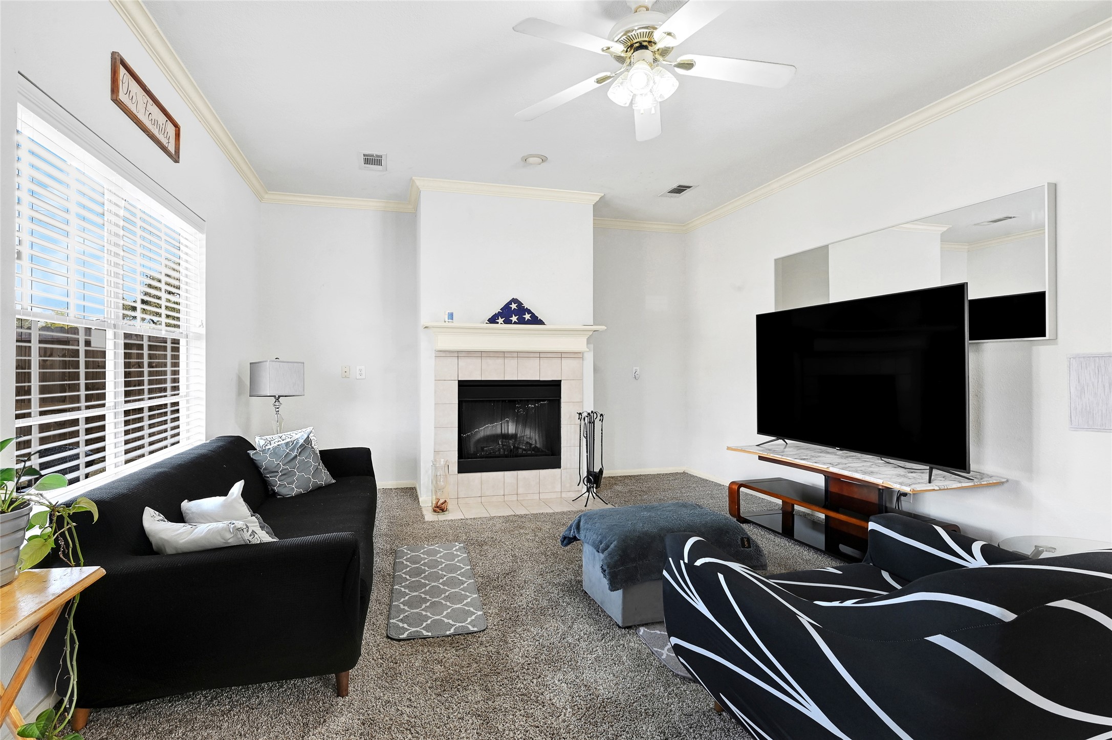 10100 Spring Pl Drive Houston, TX 77070 - Photo 8 of 24 Comfortable living room featuring a fireplace and large windows for natural light.