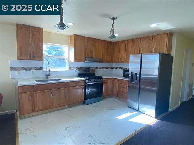 150 Rodeo Avenue Rodeo, CA 94572 - Photo 6 of 20 a kitchen with granite countertop a refrigerator a sink and dishwasher