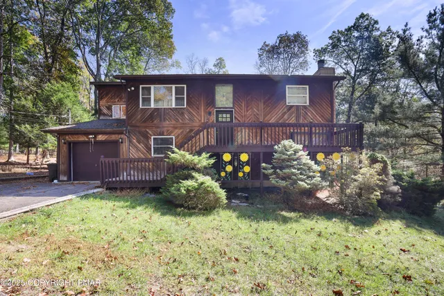 a front view of a house with a yard and a garden