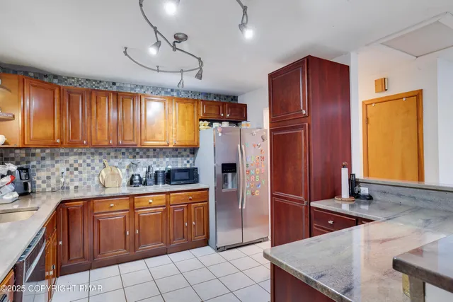 a kitchen with stainless steel appliances granite countertop a refrigerator and a sink