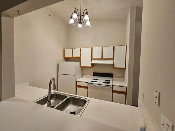 a kitchen with stainless steel appliances granite countertop a sink a stove and a refrigerator