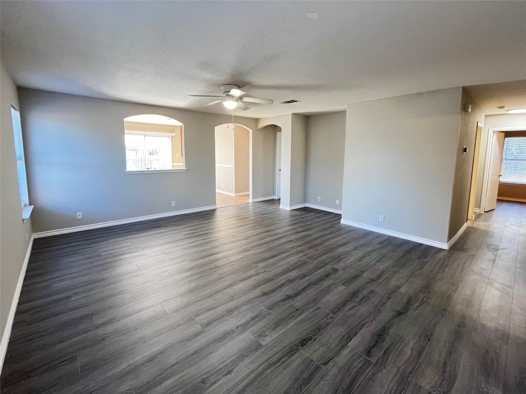 206 Presidio Drive Leander, TX 78641 - Photo 2 of 14 an empty room with wooden floor chandelier and windows