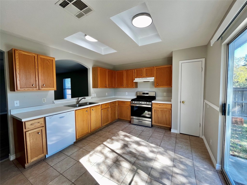 206 Presidio Drive Leander, TX 78641 - Photo 3 of 14 a kitchen with stainless steel appliances kitchen island granite countertop a stove refrigerator and cabinets