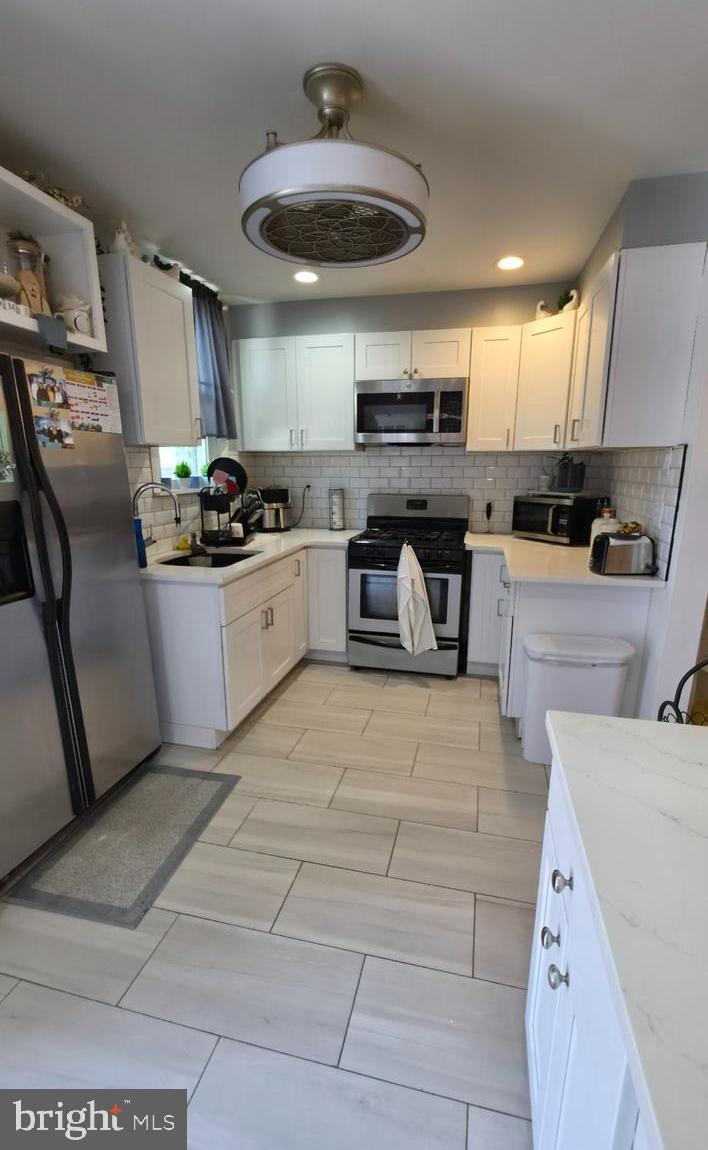 4113 Comly Street Philadelphia, PA 19135 - Photo 9 of 21 a large kitchen with stainless steel appliances kitchen island granite countertop a sink and cabinets