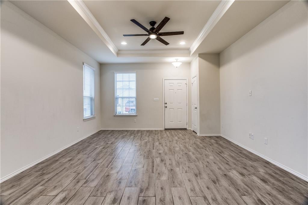 1413 Cliffbrake Way Georgetown, TX 78626 - Photo 3 of 30 an empty room with wooden floor ceiling fan and windows