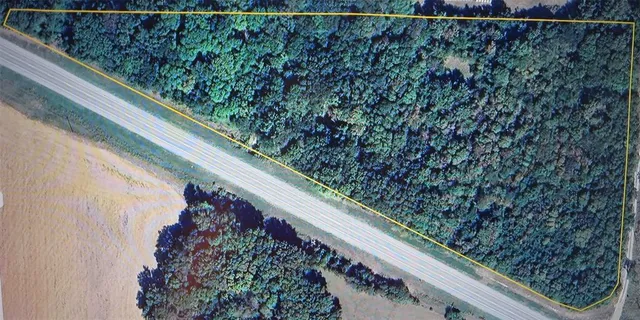 a view of a yard with a wooden fence