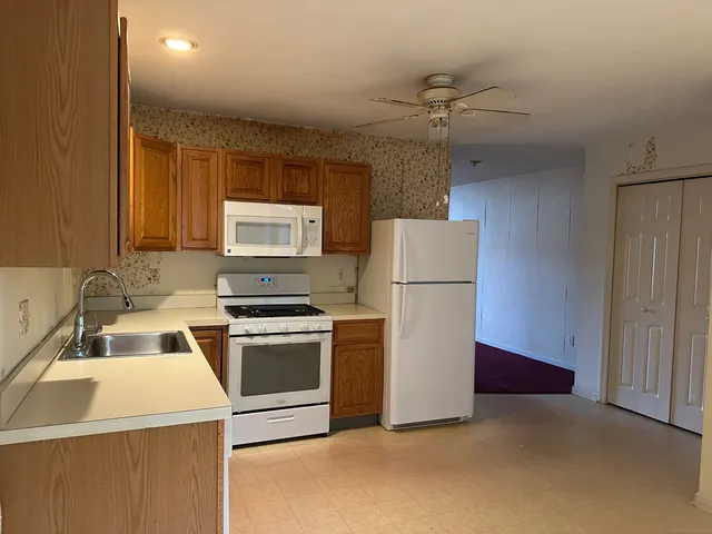 a kitchen with a refrigerator sink and cabinets