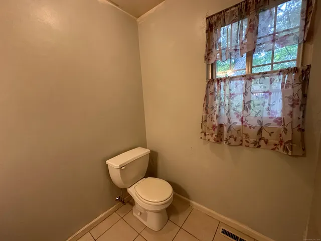 a white toilet sitting next to a shower curtain