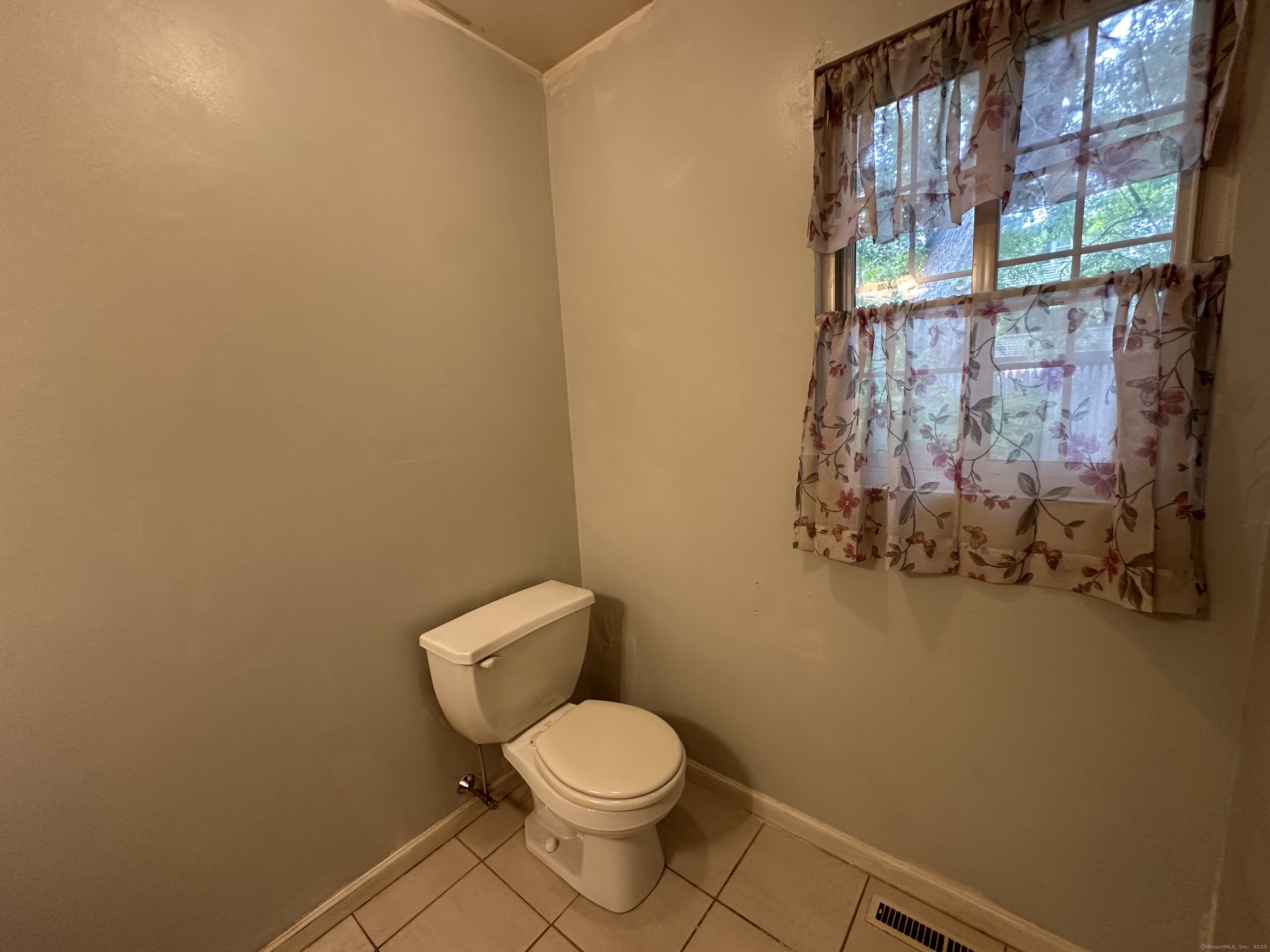 7 Howard Avenue, Unit 3 Ansonia, CT 06401 - Photo 5 of 15 a white toilet sitting next to a shower curtain