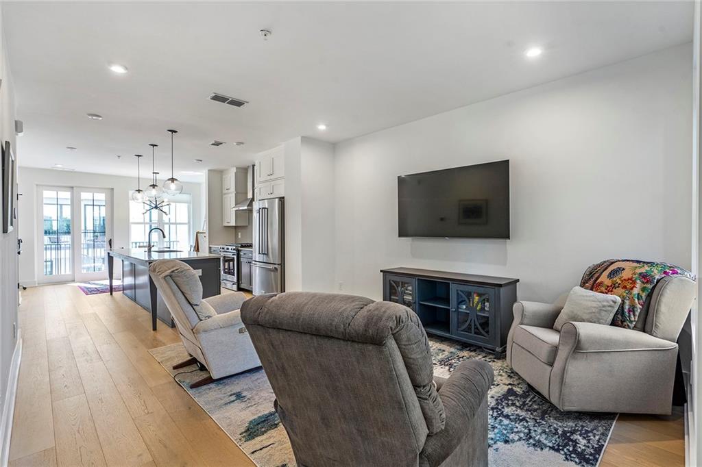 230 New Street, Unit 1201 Decatur, GA 30030 - Photo 13 of 29 a living room with furniture and a flat screen tv