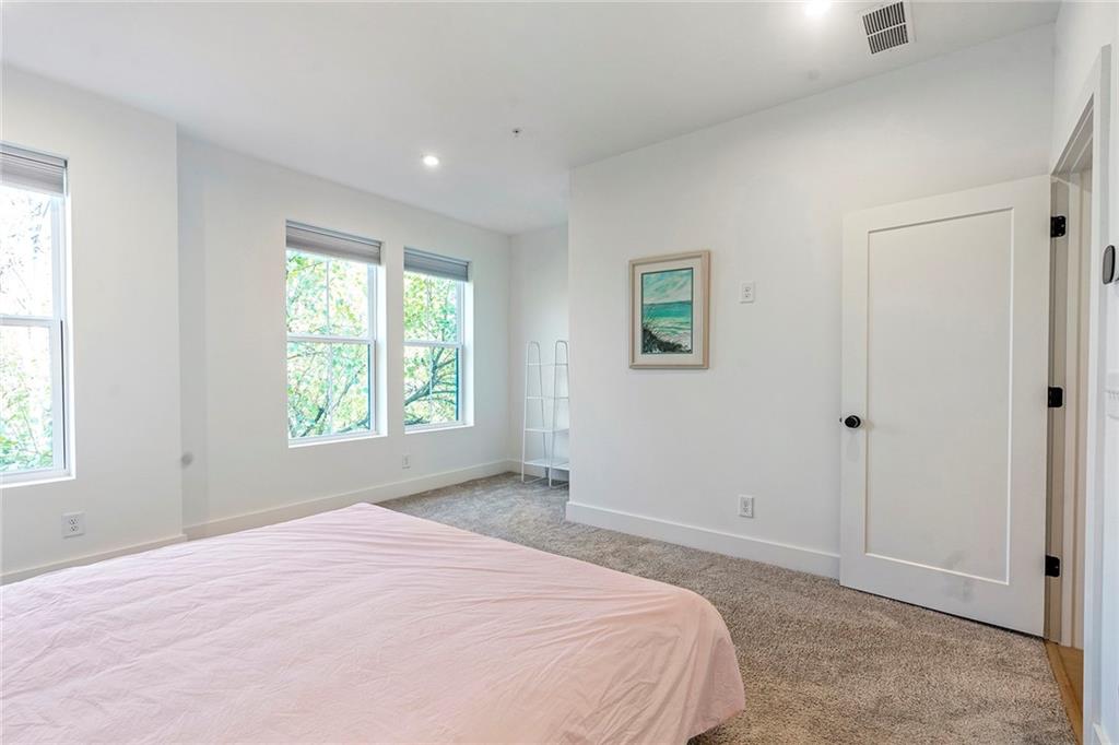 230 New Street, Unit 1201 Decatur, GA 30030 - Photo 20 of 29 a spacious bedroom with a bed and a window