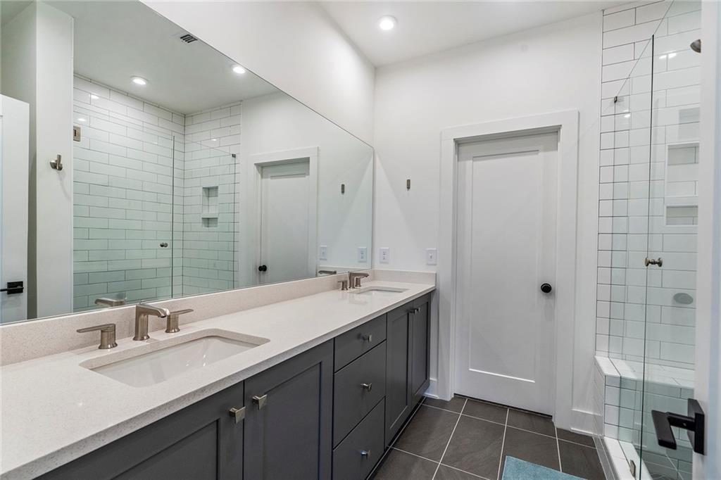 230 New Street, Unit 1201 Decatur, GA 30030 - Photo 21 of 29 a spacious bathroom with a double vanity sink a toilet and a mirror
