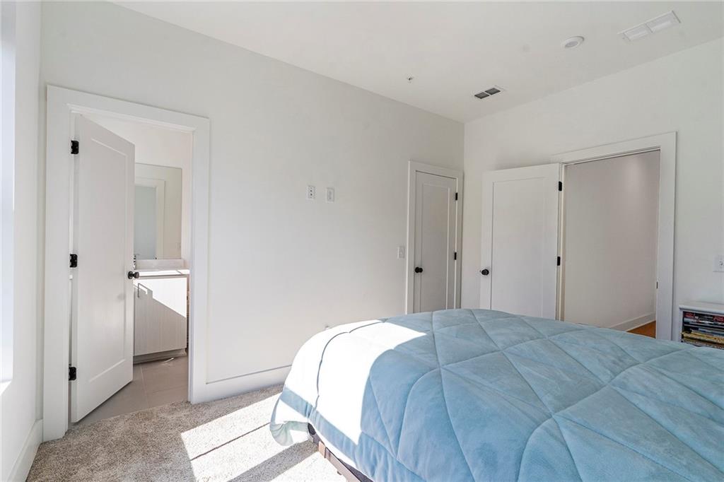 230 New Street, Unit 1201 Decatur, GA 30030 - Photo 24 of 29 a bedroom with a bed and hallway