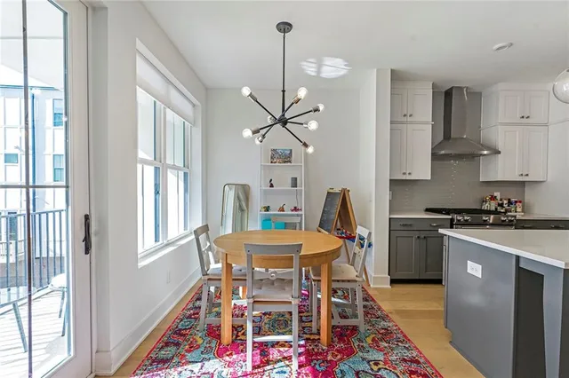a large white kitchen with a stove a sink dishwasher and a refrigerator with wooden floor