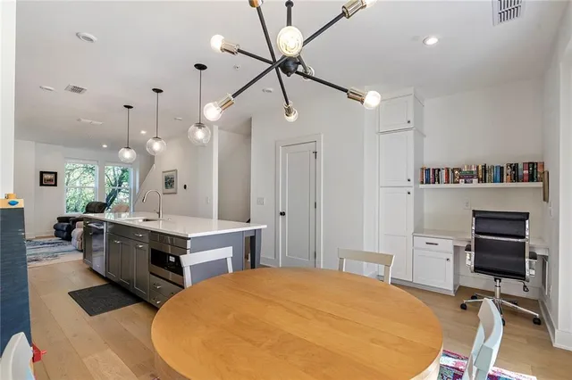 a large kitchen with stainless steel appliances a stove center island a dining table and chairs