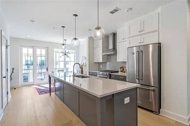 a kitchen with stainless steel appliances granite countertop a sink a stove and a wooden floors