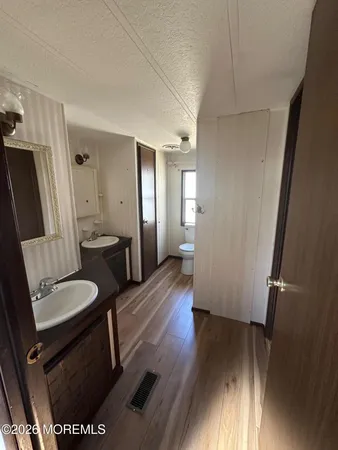 a view of a hallway with furniture and wooden floor