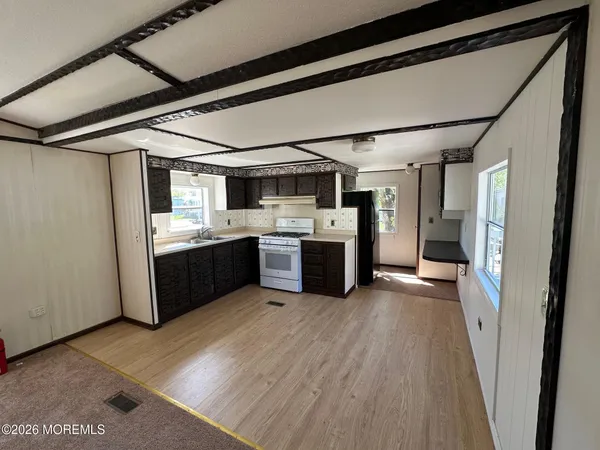 a kitchen with stainless steel appliances granite countertop a sink refrigerator and cabinets