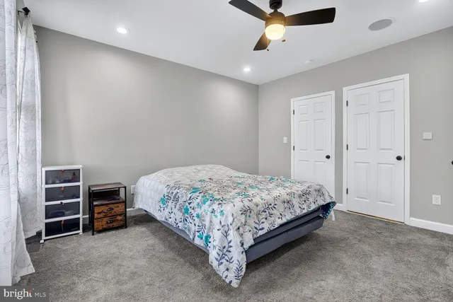 a spacious bedroom with a bed and a ceiling fan