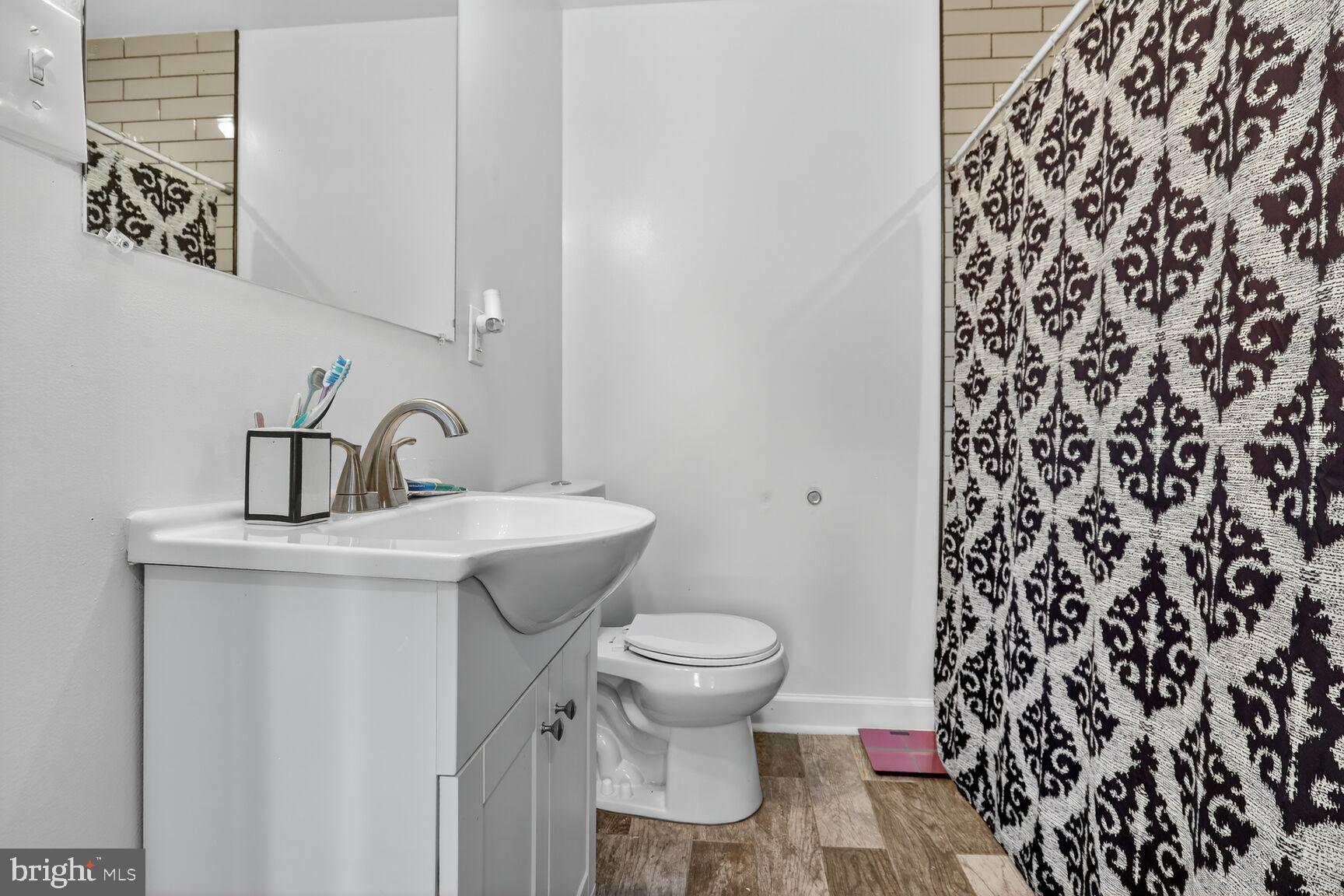 1502 East Hoffman Street Baltimore, MD 21213 - Photo 19 of 30 a bathroom with a sink toilet and a mirror