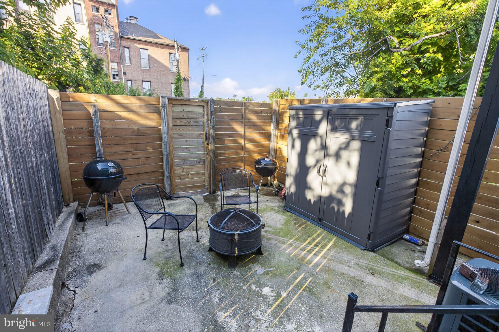 1502 East Hoffman Street Baltimore, MD 21213 - Photo 27 of 30 a view of a patio with table and chairs and wooden fence