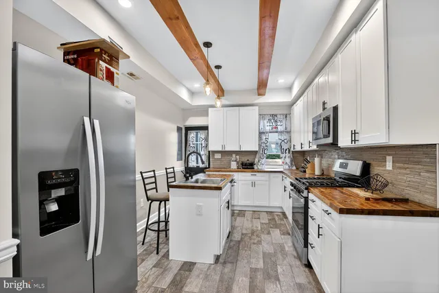 a kitchen with stainless steel appliances a refrigerator a sink a stove a microwave and cabinets