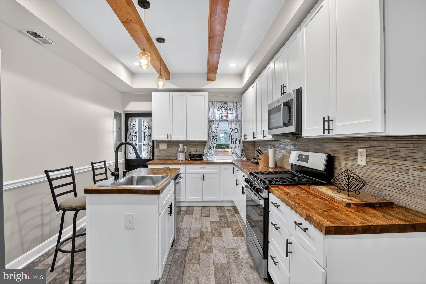 1502 East Hoffman Street Baltimore, MD 21213 - Photo 9 of 30 a kitchen with granite countertop a sink a counter space appliances and cabinets