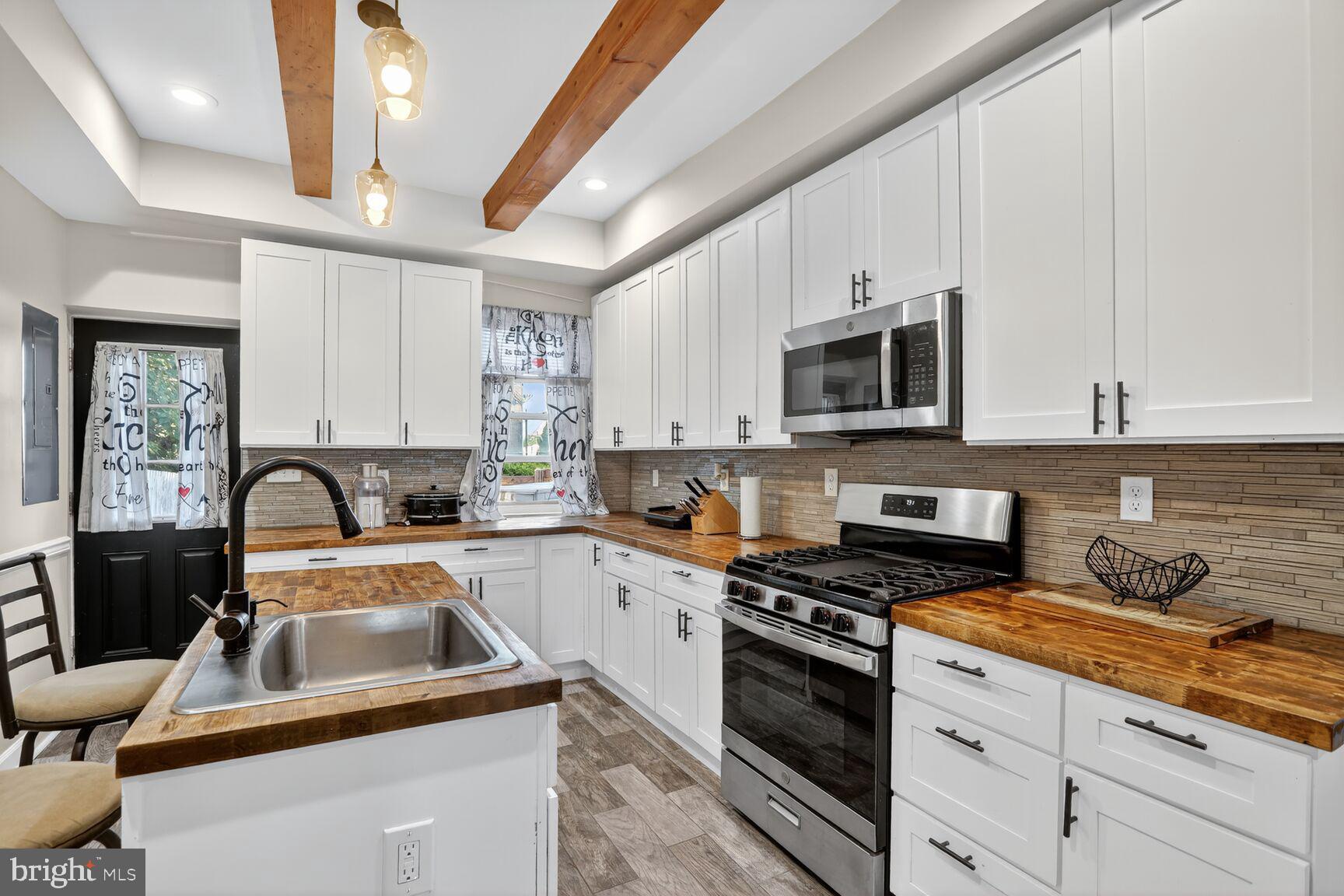 1502 East Hoffman Street Baltimore, MD 21213 - Photo 10 of 30 a kitchen with granite countertop a sink a stove and cabinets