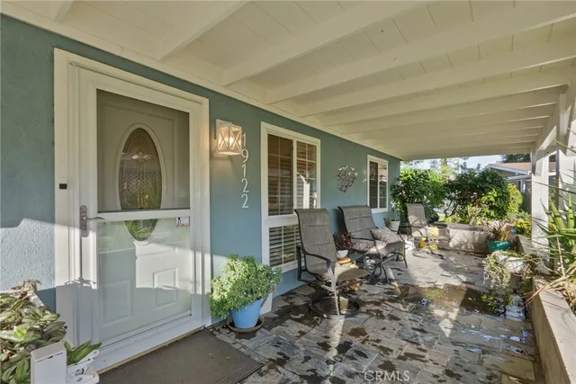 a view of a porch with chairs and backyard