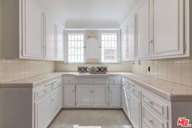 a kitchen with stainless steel appliances a refrigerator and white cabinets
