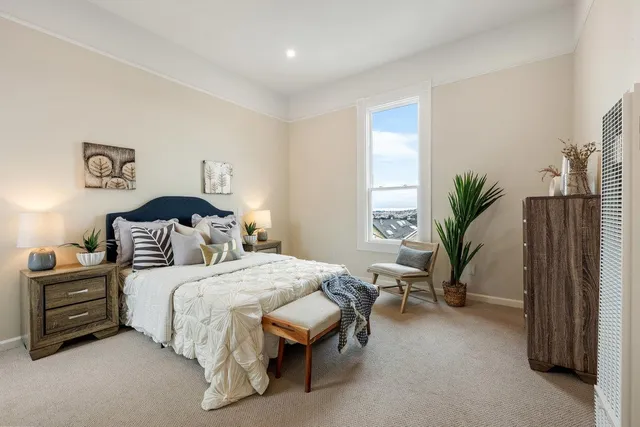 a bedroom with a bed and a potted plant