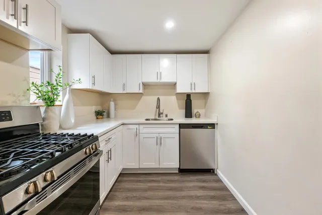 a kitchen with a stove and white cabinets
