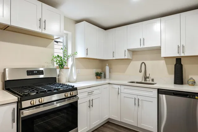 a kitchen with white cabinets and appliances
