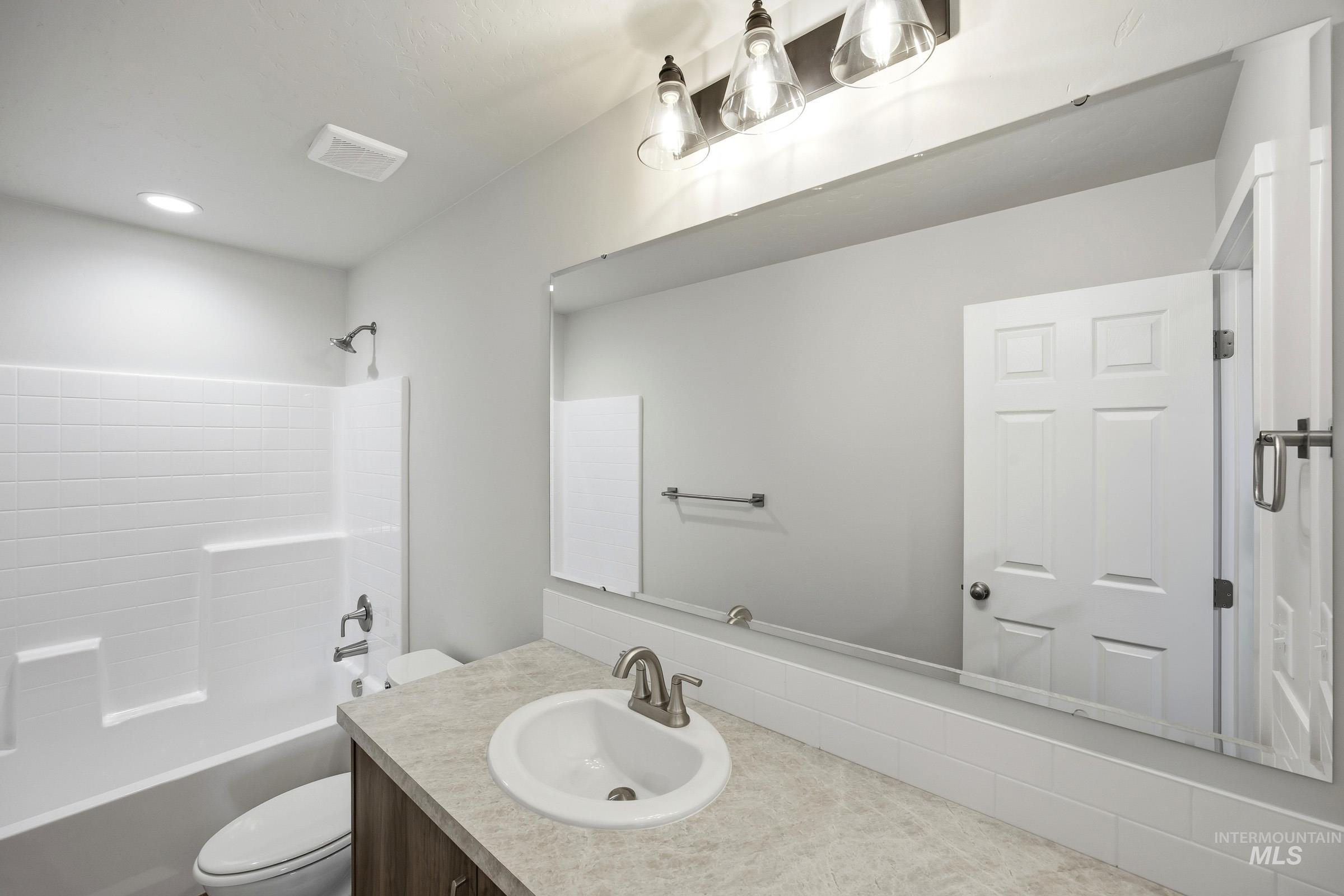 14044 Shiny Spruce Street Caldwell, ID 83607 - Photo 20 of 24 Bathroom vanity with a white oval sink, brushed nickel faucet, and a large mirror