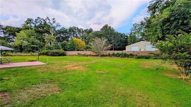 a view of a house with a big yard and large trees