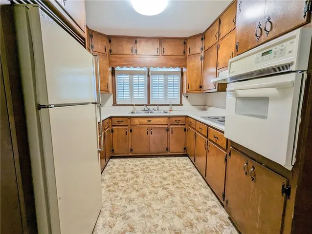 a kitchen with a refrigerator sink and cabinets