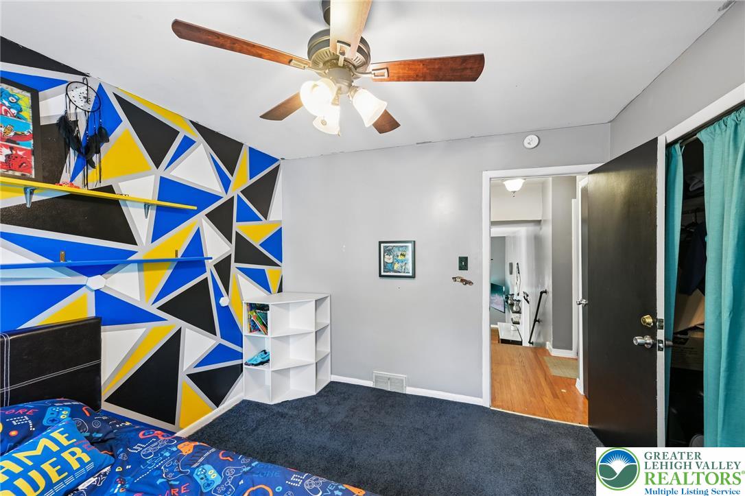 2649 Nottingham Road Bethlehem, PA 18017 - Photo 21 of 49 Bold geometric patterns accent a vibrant bedroom, complemented by plush carpeting and convenient built-in shelving.