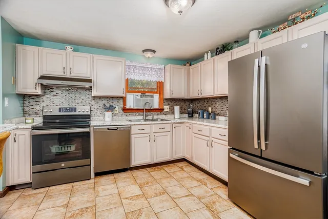 a kitchen with granite countertop white cabinets and white appliances