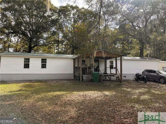 a view of a house with a yard and sitting area