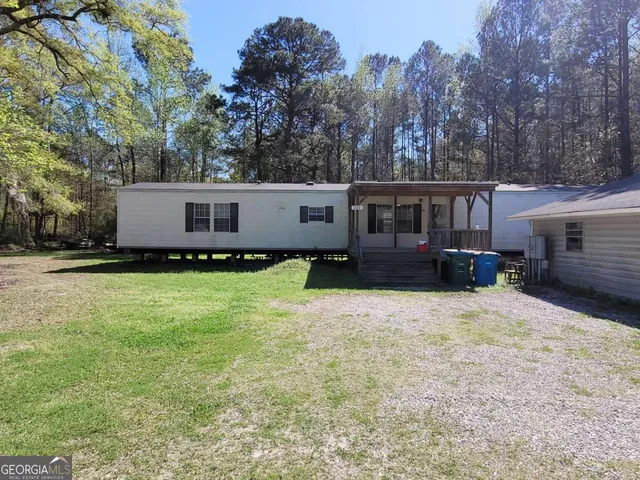 a front view of a house with a yard and trees