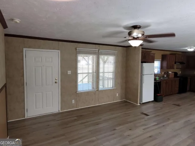 a view of a livingroom with a ceiling fan window and wooden floor